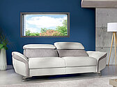 Sofa Sahara belo siva, izrađena u štofu i koži u modernom ambijentu kojim vladaju plava i bela boja